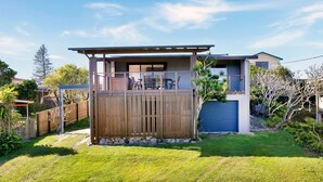 A modern two-story house with a fenced patio and a garage. - Hibiscus Dreaming - Brooms Head Village Location (Brooms Head)