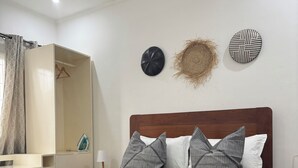 Une chambre bien rangée, avec un lit, des tables de chevet et une armoire.