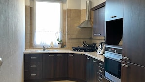 Una cocina moderna con gabinetes de madera oscura, una campana extractora de acero inoxidable y un horno empotrado.