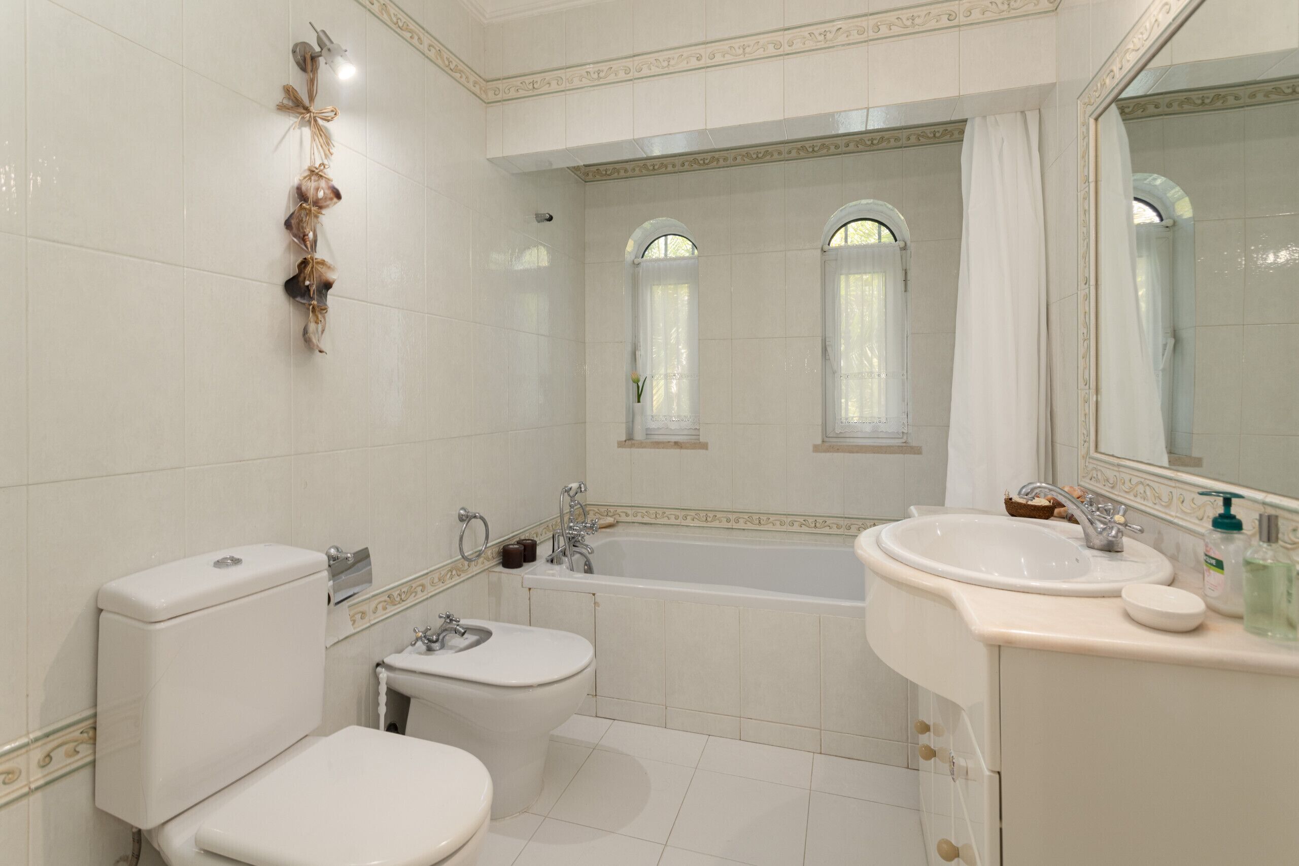 Ein Badezimmer mit Toilette, Bidet, Badewanne und einem großen Spiegel.
