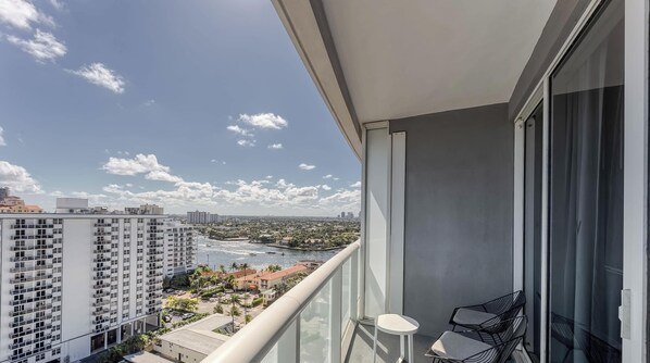 Ein Balkon mit Blick auf einen Fluss, Gebäude und einen klaren Himmel.