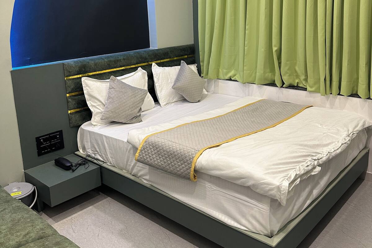 Un dormitorio moderno con una cama grande, una mesita de noche con regleta y aire acondicionado instalado en la pared.