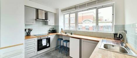 Un four, surface de cuisson, cafetière-théière, grille-pain