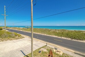 Eine Küstenstraße mit Blick auf den Strand, eine Holzkonstruktion und Strommasten.