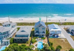 A coastal property with multiple buildings, a swimming pool, and a view of the ocean.