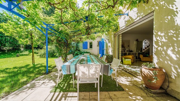 An outdoor dining area with a table and chairs, surrounded by greenery and a blue pergola. - Pet friendly home in Aix-En-Provence (Aix-En-Provence)