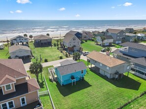 A coastal residential area with houses, a beach, and a clear sky. - Welcome to Blue Jewel! (Galveston)