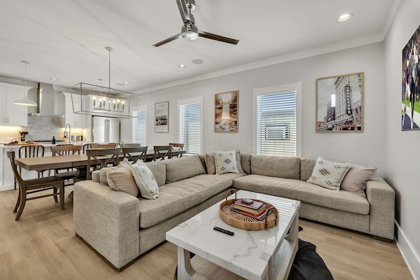 Unit 2 - 2nd Floor: Warm and inviting open-concept living space seamlessly flowing the designer furnished living room with the fully equipped kitchen and dining area.