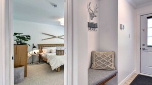 A bedroom with a bed, bedside table, lamp, and a wall-mounted deer head decoration.