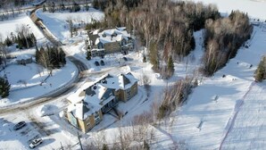 A large, multi-story residential building with a snow-covered roof and surrounding area.