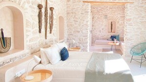 Una stanza con pareti in pietra, un divano, un tavolino e una sedia.
