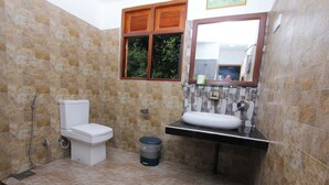 A compact bathroom with a toilet, sink, and shower. - Blue Ribbon Homestay  (Ella)