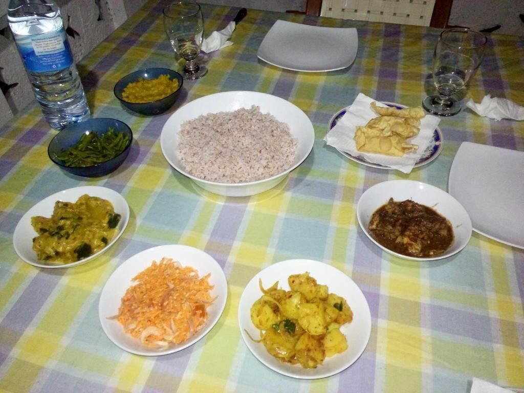 A table with various dishes and a bottle of water.