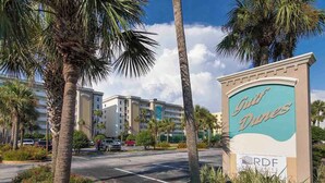 A hotel entrance with palm trees and a sign for 'Duke Dunes'.