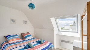 Une chambre à coucher avec un lit, une fenêtre et un ventilateur de plafond.