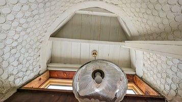 Experience the unique charm of this room with a sloped ceiling, featuring a textured wall design and a wooden bench.