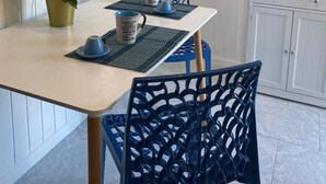 Un coin repas comprenant une table, des chaises, une plante en pot et un four à micro-ondes.