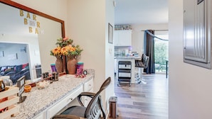 A modern kitchen with a granite countertop, a coffee machine, and a vase with flowers.