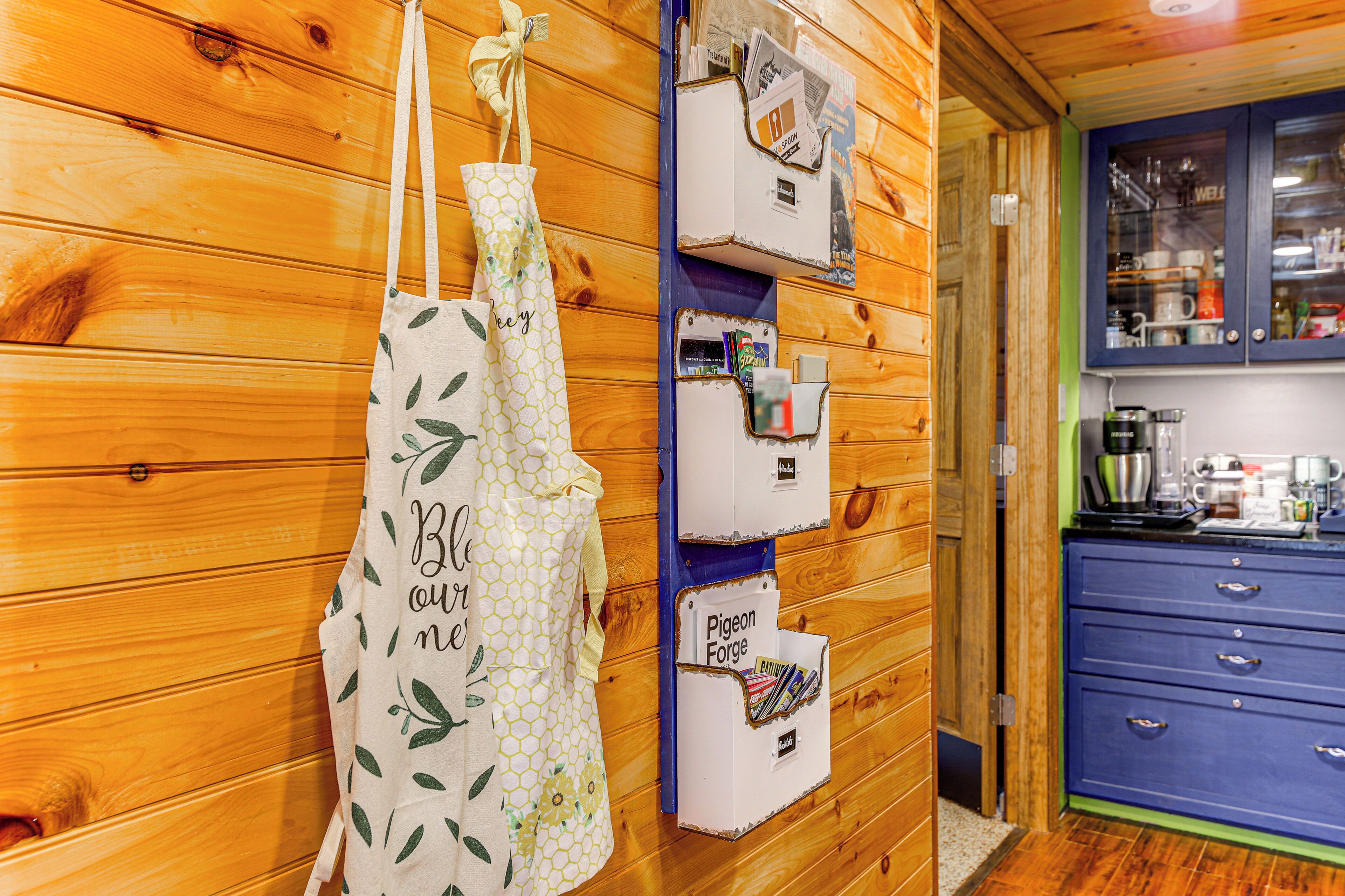 A wooden interior with a kitchen area featuring cabinets and a blue countertop.