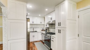 A kitchen with white cabinets, a stainless steel stove, and a tiled backsplash. - Del Rey Oaks Vacation Home w/ Mini-golf Course! (Monterey)