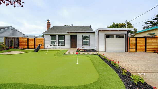 A residential property with a well-maintained lawn, a golf cart, and a garage. - Del Rey Oaks Vacation Home w/ Mini-golf Course! (Monterey)