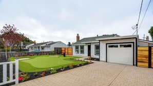A residential property with a well-maintained lawn, a garage, and a brick driveway. - Del Rey Oaks Vacation Home w/ Mini-golf Course! (Monterey)