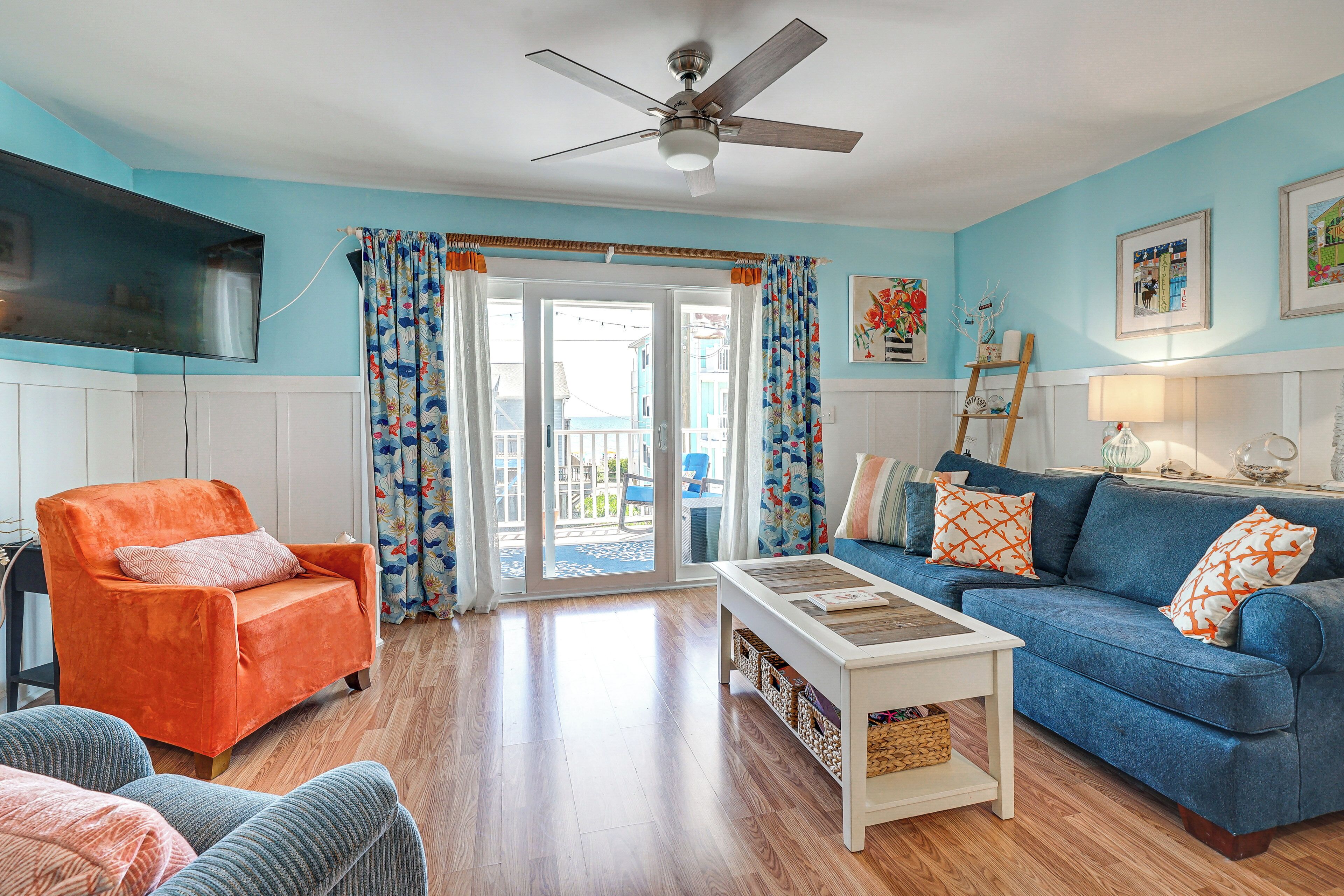 A living room with a blue sofa, orange armchair, and a white coffee table.