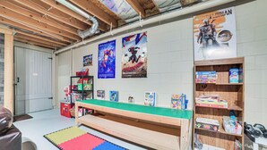 A playroom with LEGO sets, posters, and a play mat.