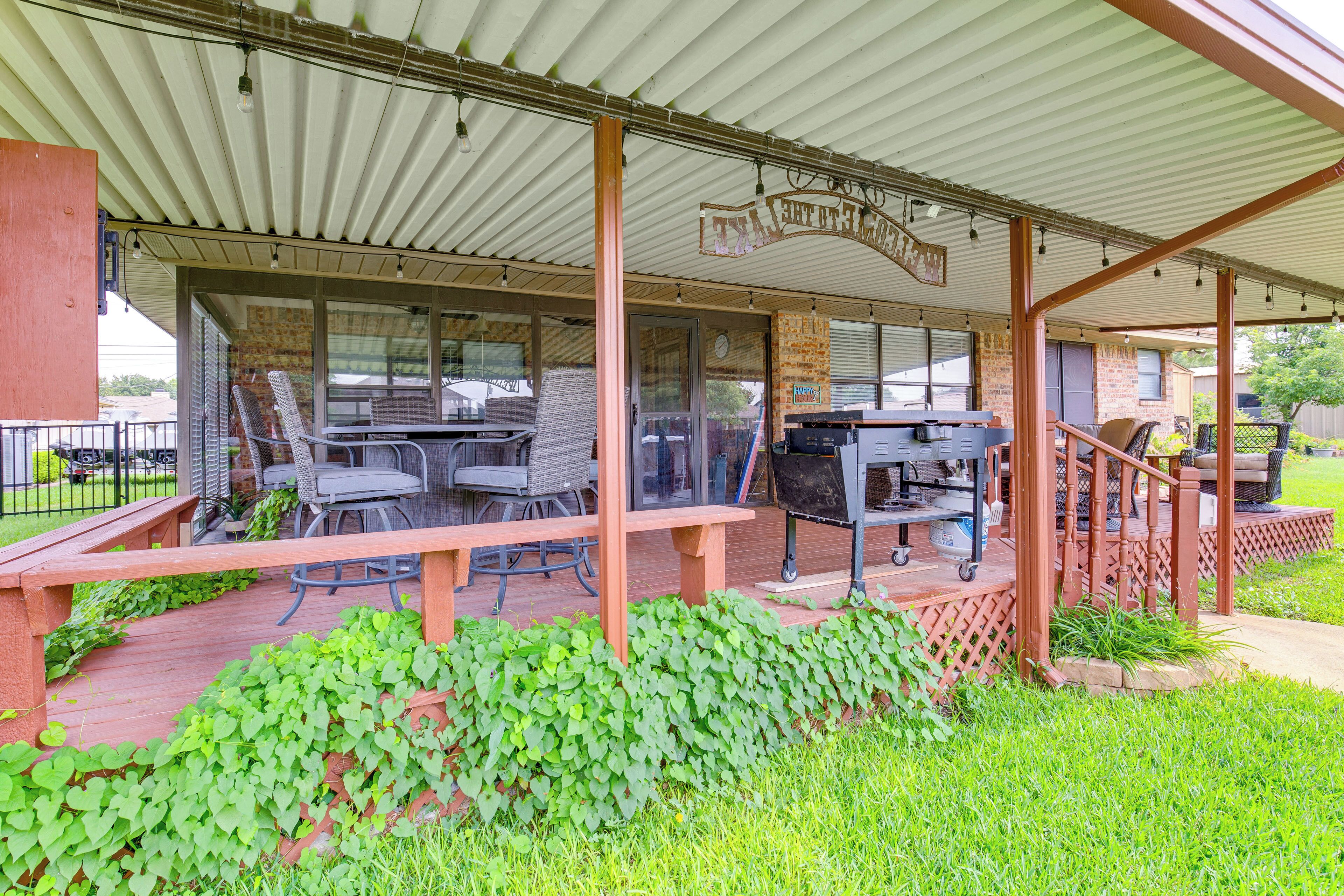 A covered outdoor patio with a grill, seating, and a sign reading "The Country Club."
