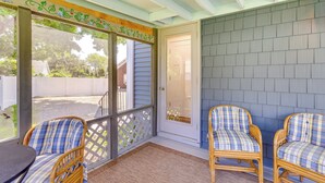 A covered porch with two wicker chairs, a wooden table, and a decorative ceiling. - Old Saybrook Home w/ Screened Porch & Ocean View! (Old Saybrook)