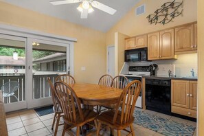 A compact kitchen with wooden cabinets, a microwave, stove, and dishwasher.