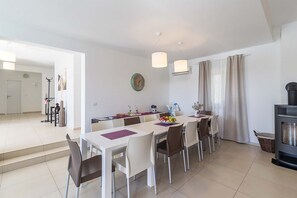 Un comedor moderno con una mesa larga, sillas y un reloj en la pared.