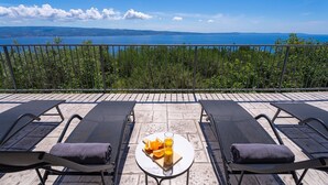 A terrace with lounge chairs and a table with fruit and a drink. - Seaview Villa Roko with heated pool (Jesenice, Dugi Rat)