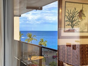 A balcony with a view of the ocean and palm trees. - Fully Remodeled Studio at Mana Kai Resort (Kihei)