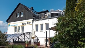 Kaksikerroksinen rakennus, jonka kyltissä lukee ”Auto Ziff”, ja joka osoittaa autokorjaamon sijainnin.