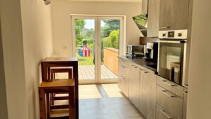 Una cucina con una porta scorrevole in vetro che dà su un patio, un forno a microonde e un fornello.