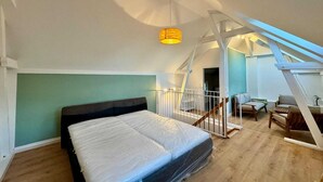 Una camera da letto con un letto, una scala e una lampada a sospensione.