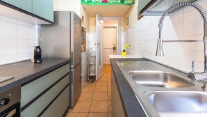 Eine moderne Küche mit Edelstahlgeräten, einer Spüle und einer gefliesten Rückwand.