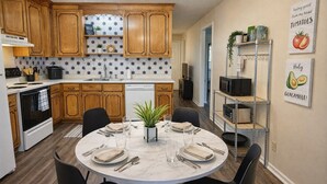 A modern kitchen with wooden cabinets, a white stove, and a dining table set for four. - 5 Minutes to VSU, I-75 & Restaurants! Sleeps 5 w/ 2 Full Baths- Family Friendly (Remerton)