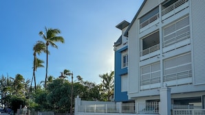 A multi-story building with a modern architectural design, featuring balconies and large windows. - EVASION SAINT LEU, APARTMENT 100 M FROM THE SEA  (Saint-Leu)