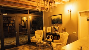 A living room with a fireplace, a coffee table, and two armchairs.