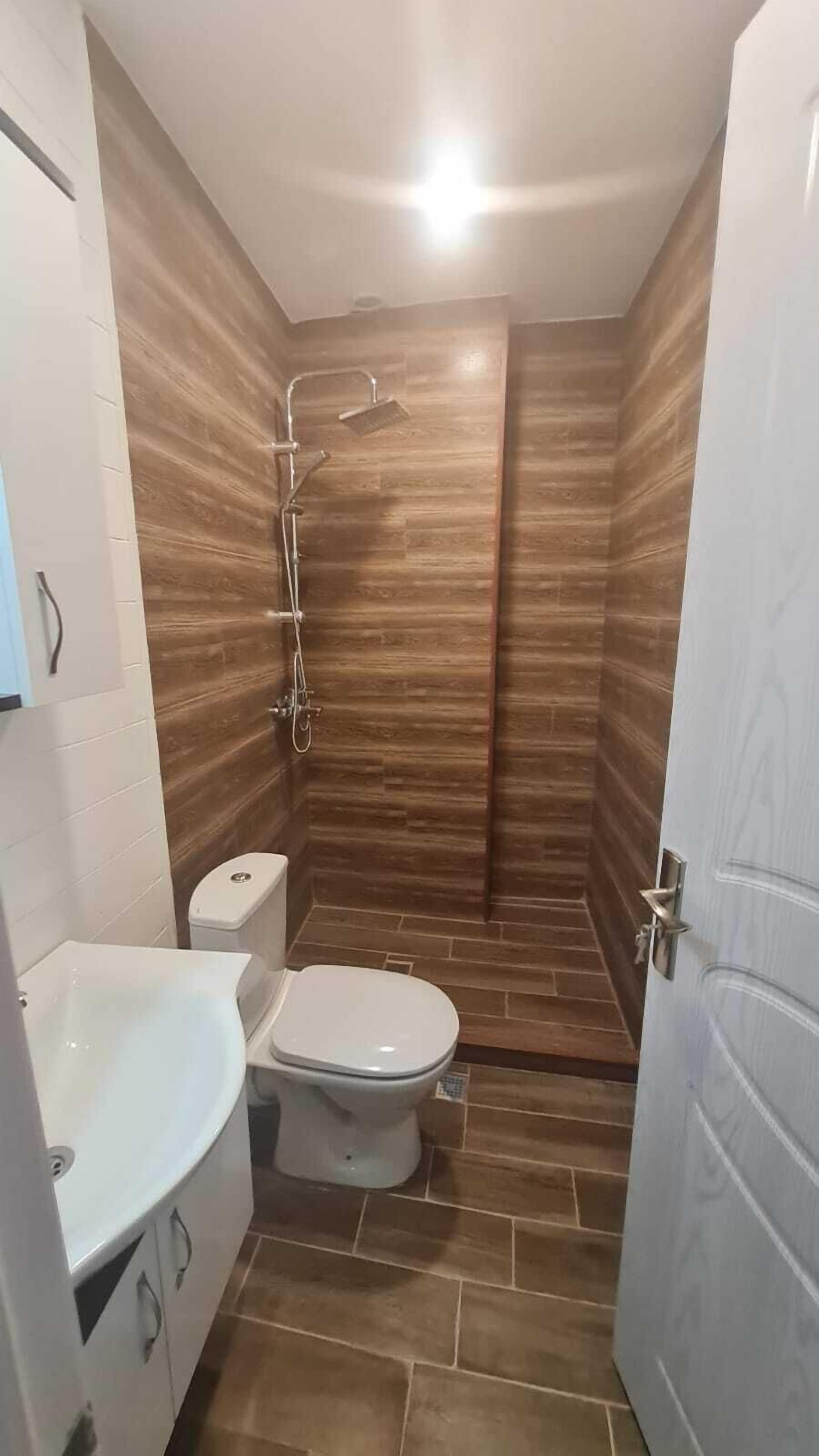 A bathroom with a shower, toilet, and sink.
