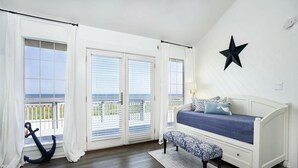 A bedroom with a bed, bench, and a star decoration on the wall.