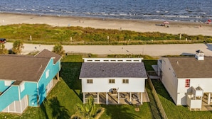 A beachfront property with a house featuring a patio and a small pool.