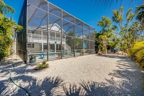A modern house with a glass enclosure, a pool, and a well-maintained garden.