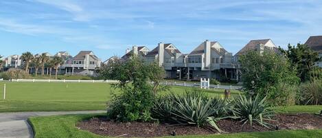 A residential area with modern houses, a well-maintained lawn, and a clear sky.
