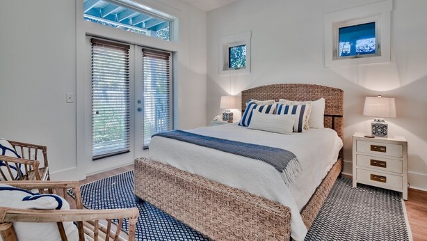 A bedroom with a large bed, two bedside tables, a window with blinds, a ceiling fan, and a small window above the bed. - Beautiful Home in Seagrove Beach “The Chart House”, Close to Seaside and 7 minut (Santa Rosa Beach)