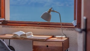 A wooden desk with a lamp, an open book, and a cup. - Villa Bianca Lierna by Varenna Holidays (Varenna)