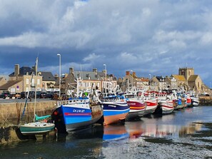 A harbor with multiple boats docked along the waterfront, surrounded by buildings and a clear sky. - Le Gîte de la Grange de Dîme. Gite Tout Confort à 1 km du Phare de Gatteville (Gatteville-le-Phare)
