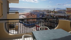 A balcony with a view of the sea and buildings. - Jardín II, 5º Solo Familias (Xeraco Playa)